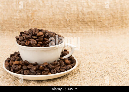 Tazza di caffè riempiti con fagioli arrosto sulla iuta area di testo o spazio di copia Foto Stock