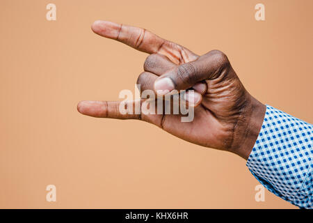 Maschio, uomo, hipster, in camicia, mano alzata illustrante un metallo pesante segno di roccia Foto Stock