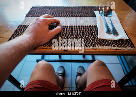 Uomo in attesa per la cena in cafe. folk e cucchiaio giacciono vicino a. vista come è selphie. concetto per la dieta Foto Stock