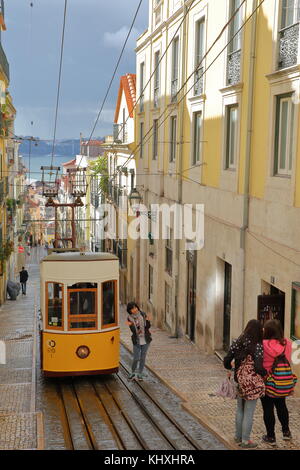 LISBONA, PORTOGALLO - 4 NOVEMBRE 2017: La funicolare Elevador da Bica con turisti giapponesi che scattano foto e il fiume Tago sullo sfondo Foto Stock