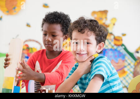 Kindergarten studenti sorriso quando si gioca giocattolo in sala giochi in età prescolare,internazionale il concetto di istruzione Foto Stock