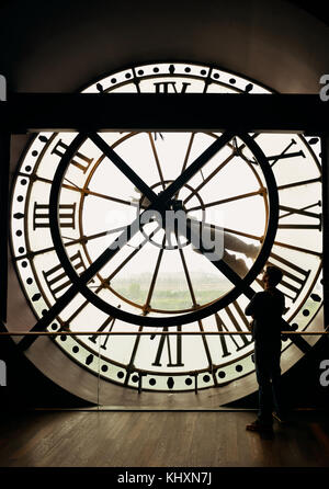 Un turista in cerca thrugh gigantesco orologio torre a Parigi, Francia. Foto Stock