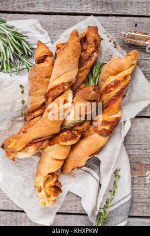 Gustoso formaggio bastoni con pancetta, erbe e salsa di pomodoro. vista dall'alto, sullo sfondo di legno. carne formaggio snack per la birra e il concetto di partito, la Giornata del ringraziamento. Foto Stock