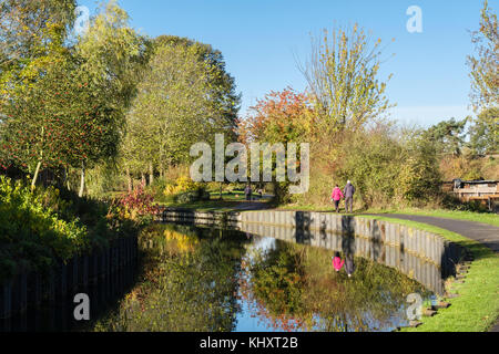 La gente che camminava sul Droitwich canal alzaia in vigne Parco in autunno. Droitwich Spa, Worcestershire, Inghilterra, Regno Unito, Gran Bretagna Foto Stock