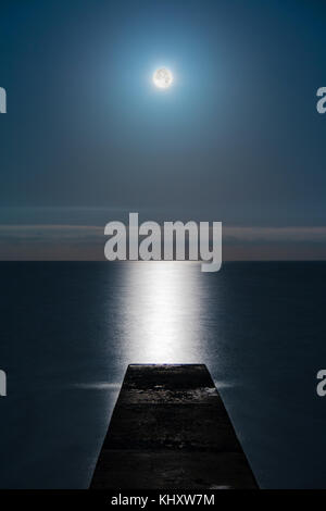 Seascape con la luna piena sul mare e la mole in linea con la luna glade Foto Stock