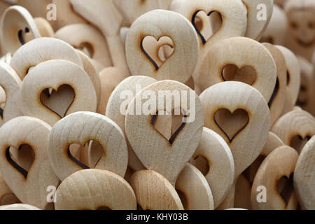 Chiudere fino a mano in legno rustico mestoli con scolpito forma di cuore al mercato retail display di stallo Foto Stock