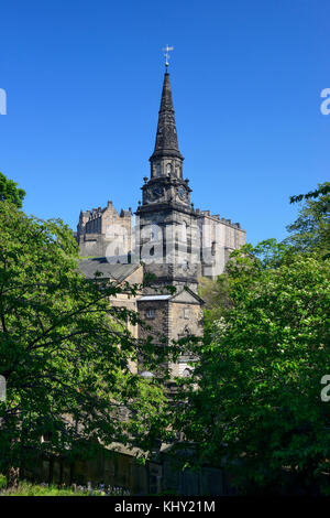 Campanile della chiesa parrocchiale di st cuthbert, con il castello di Edimburgo in background, visto da St Cuthbert's cimitero nel centro di Edimburgo, Scozia Foto Stock