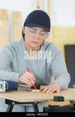 Ritratto di donna felice falegname redazione nuovo progetto in officina Foto Stock