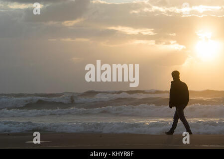 Ramlet Al Baida, Beirut Libano, XXI Nov, 2017. Stagliano giovane uomo a camminare sulla spiaggia al tramonto. Beirut Libano, Credito : Mohamad Itani/ Alamy Live News Foto Stock