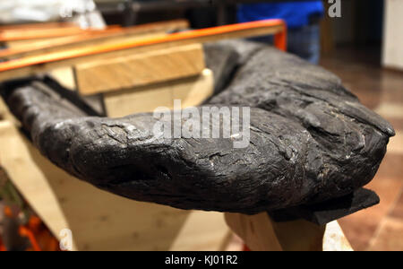 Ettal, Germania. 23 novembre 2017. Una longboat celtica parzialmente svelata, di circa 3000 anni, fatta di quercia, in mostra nel Monastero Ettal di Ettal, in Germania, il 23 novembre 2017. L'oggetto lungo 15,5 metri e pesante più di due tonnellate è una mostra dell'esposizione statale bavarese del 2018 "Foresta, montagna e magicamente sogno - il mito della Baviera" nel monastero Ettal. La longboat, trovata nel lago Starnberg negli anni '1980, fu presentata per la prima volta al pubblico dopo decenni di lavori di restauro. Crediti: Karl-Josef Hildenbrand/dpa/Alamy Live News Foto Stock