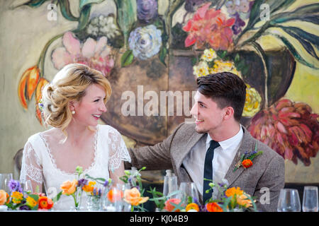 Sposa e lo sposo seduti al tavolo superiore al ricevimento di nozze Foto Stock