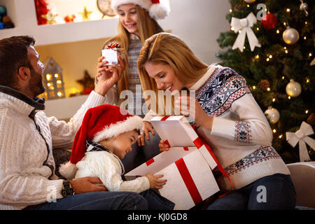 La famiglia felice in decorate home gioisce con regalo di natale Foto Stock