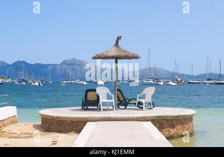 Ombrellone e sedie vuote con vista mare in Port de pollenca a Mallorca, Spagna. Foto Stock