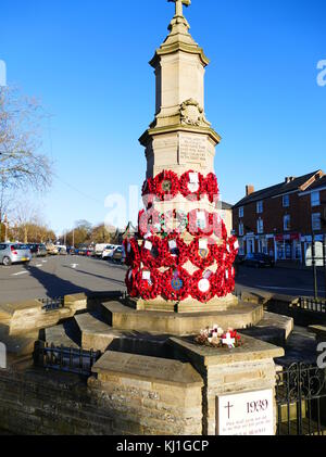 Prima Guerra Mondiale monumento con semi di papavero ghirlande; a Brackley in un villaggio nel Northamptonshire, Inghilterra. Foto Stock