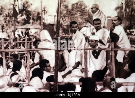 Mohandas Karamchand Gandhi 1869 - 1948) leader preminente dell'Indiano movimento di indipendenza in British-governata India affrontando un Congress Party Rally 1932. Alla sua destra siede Jivatram Kripalani, noto come Acharya Kripalani, è stato un uomo politico indiano, nota soprattutto per la presidenza del Congresso nazionale indiano Foto Stock