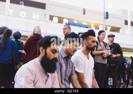 Manifestanti lotta contro Donald Trump musulmana del divieto di viaggio. Uomini pregando davanti a tom bradley international airport. Foto Stock