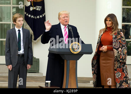 Il presidente degli Stati Uniti Donald J. Trump, al centro, fa delle osservazioni come Barron Trump, a sinistra, e First Lady Melania Trump, a destra, guardano su come ospitano la cerimonia Nazionale di Perdono della Turchia nel Giardino delle Rose della Casa Bianca di Washington, DC lunedì 20 novembre 2017. Secondo la White House Historical Association, la cerimonia ebbe origine nel 1863 quando il presidente americano Abraham Lincoln concesse clemenza ad una turchia. La tradizione urlò nel 1989 quando il Presidente degli Stati Uniti George HW Bush affermò: "Ma permettetemi di assicurarvi, e questo bel tom turkey, che non finirà per cenare nessuno Foto Stock