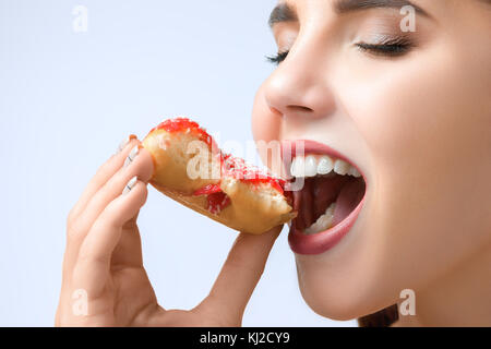 Bella donna di mordere una ciambella Foto Stock