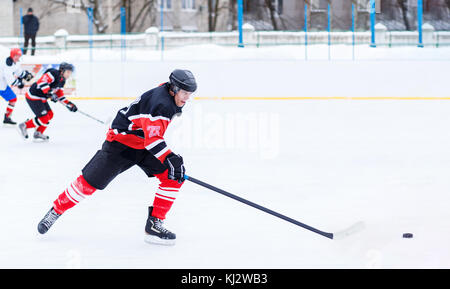 Il giovane skater uomo in attacco. ice hockey gioco immagine con spazio di copia Foto Stock