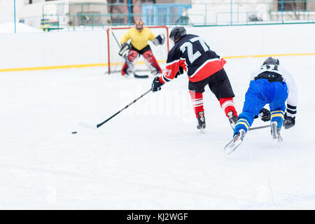 Il giovane skater uomo in attacco. ice hockey gioco immagine con spazio di copia Foto Stock