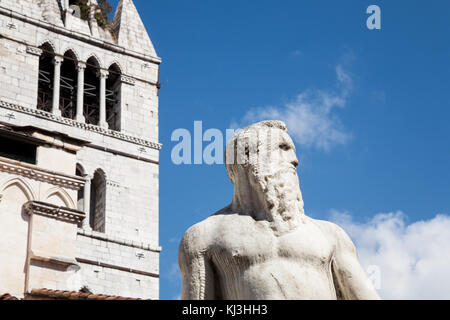 La storica statua marmorea del XVI secolo del Gigante con la torre della cattedrale sullo sfondo a Carrara in Toscana, Italia Foto Stock