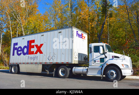 FedEx Semi carrello parcheggiato lungo un marciapiede davanti a bellissimi alberi d'autunno. Foto Stock