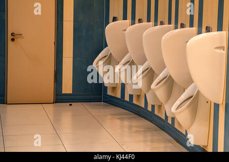 Vicino la fila di orinatoi uomini wc pubblico Foto Stock