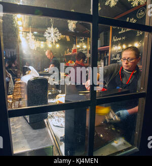 I titolari di stallo preparare cibo festoso a Edimburgo il mercatino di Natale sulla Montagnola, Edimburgo. Foto Stock