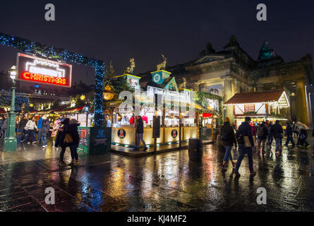 Gli acquirenti di Natale al di fuori della Edinburgh mercatino di Natale presso il Tumulo di Edimburgo. Foto Stock