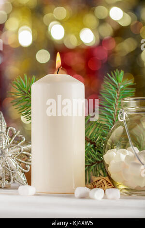 Christmas candle, marshmallow in un vasetto di vetro. Composizione di natale. pronto scheda. Foto Stock