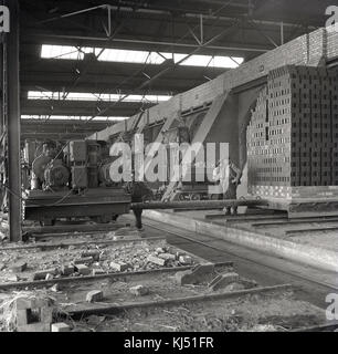 Negli anni '50, i lavoratori all'interno di una delle fornaci giganti su cui vengono sparati i mattoni vengono finiti a Stewartby, nel Bedfordshire, all'epoca la più grande fabbrica di mattoni del mondo, di proprietà della London Brick Company. Foto Stock