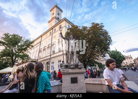 Fontana con la statua del Nettuno di fronte al municipio, su una piazza del mercato della città vecchia di Lviv, la città più grande dell'Ucraina occidentale Foto Stock