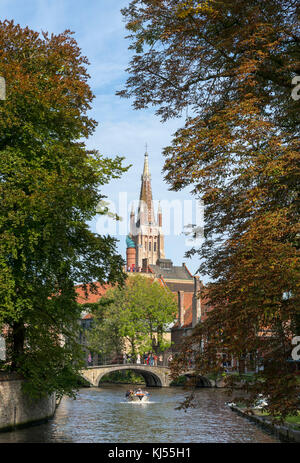 Gita in barca sul parco Minnewater guardando verso il campanile della chiesa di Nostra Signora (Onze-Lieve-Vrouwekerk), Bruges (Brugge), Belgio. Foto Stock