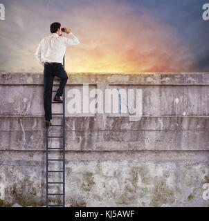 Imprenditore su un scale guarda lontano per il nuovo business Foto Stock