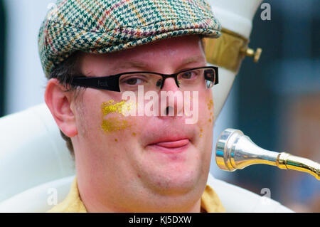 Musicista maschio con gli occhiali e un tappo piatto a giocare il sousaphone nel carnevale del edinburgh jazz e blues festival Foto Stock