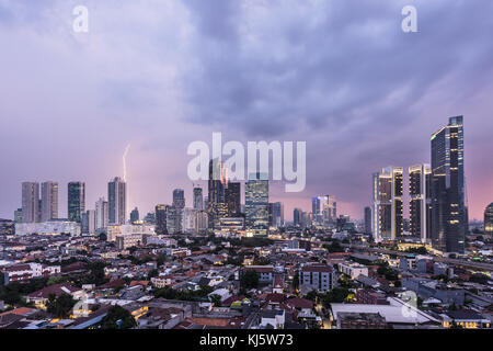 Vista aerea di un tramonto cielo caricato con nubi e un fulmine su Giacarta quartiere degli affari in Indonesia la città capitale del sud-est asiatico Foto Stock