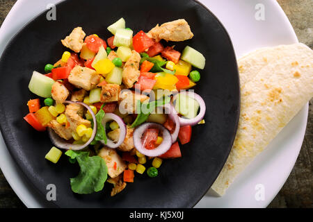 Insalata di pollo ed il tortilla pane sulla piastra dal di sopra Foto Stock