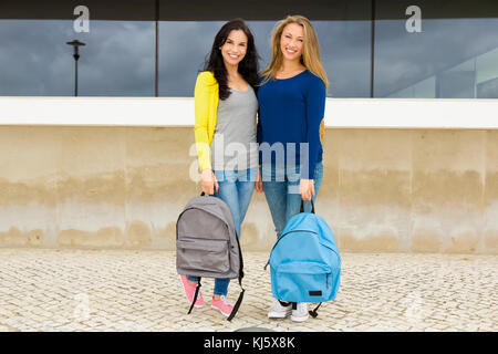 Due belle teenage studenti in possesso di zaini e sorridente Foto Stock