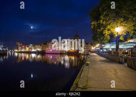 Vista delle barche e vecchi edifici sul lungo ponte waterfront presso le principali città (città vecchia) e la passeggiata lungomare a Danzica, Polonia, la sera. Foto Stock