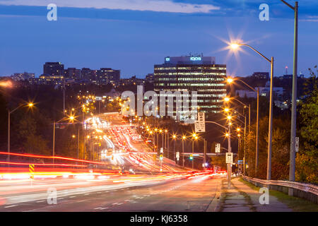 Auto lasciando sentieri di luce durante una lunga esposizione lungo Don Mills Road di notte a Toronto, Ontario, Canada. Foto Stock