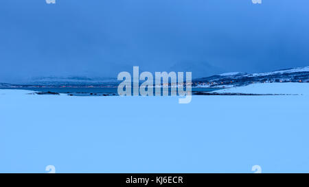 Le nuvole di un inverno mattina di gennaio. Paesaggi innevati. Le montagne e il mare in lontananza. Tisnes, Kvaløya, Tromsø, Norvegia. Foto Stock