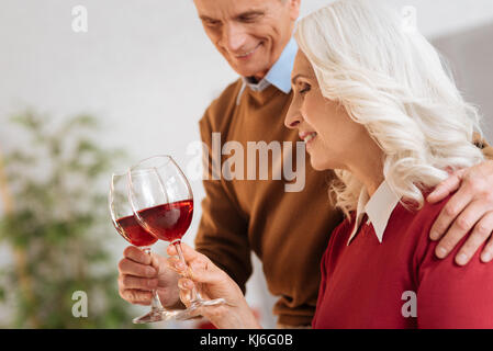 Allegro coppia sposata a bere vino rosso Foto Stock