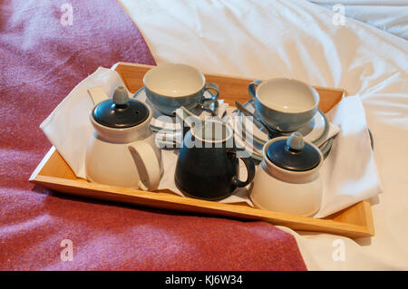 Tazze e piattini su un vassoio pronto per la colazione a letto. Foto Stock