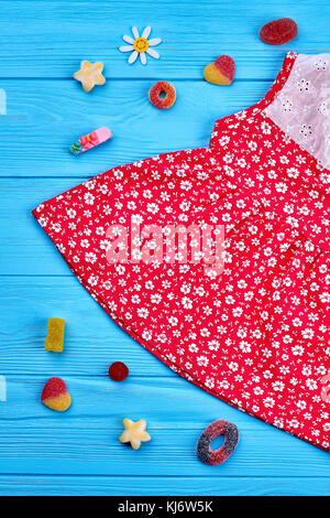 Bellissimo bambino-ragazza abito, dolci. cotone rosso vestito in stampa vintage per bambine su sfondo di legno. abbigliamento casual per little baby-ragazze. Foto Stock