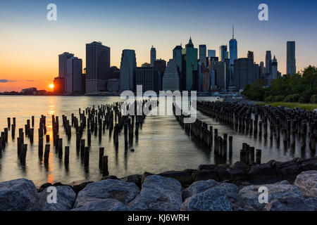 Grattacieli di Manhattan e palificazioni di legno al tramonto dal ponte di Brooklyn Park. Manhattan, New York City Foto Stock