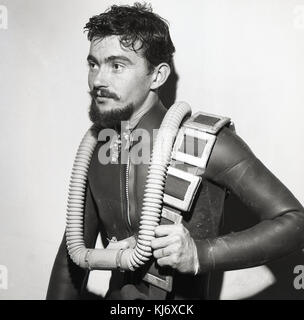 Anni sessanta, storico, immagine mostra un giovane maschio sub in una muta e apparato di respirazione. Foto Stock