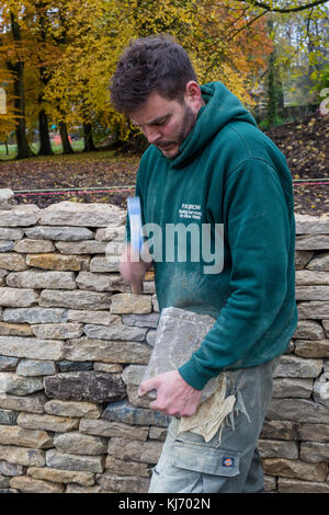 In pietra a secco parete essendo costruito in Bibury, Cotswolds, Gloucestershire, England, Regno Unito Foto Stock