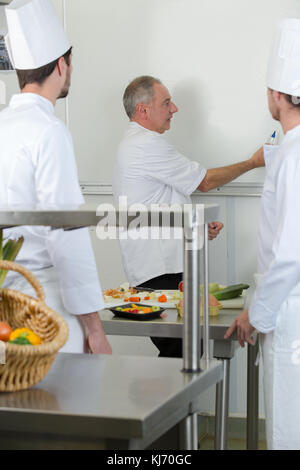 Gli studenti culinaria imparare a miscelare l'impasto in cucina Foto Stock