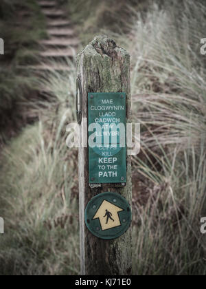 Un segno dirigere attenzione sui passi lungo il Pembrokeshire Coast Path a Tenby Pembrokeshire Foto Stock