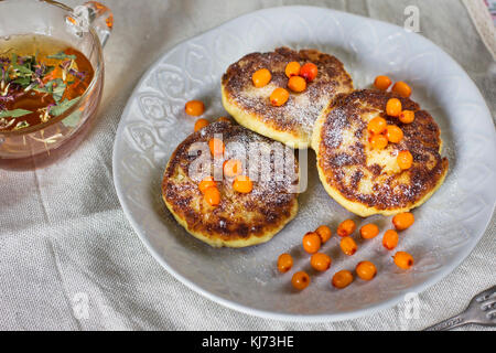 Il cottage cheese pancake con mare Frangola bacche e tè alle erbe. Una sana prima colazione Foto Stock